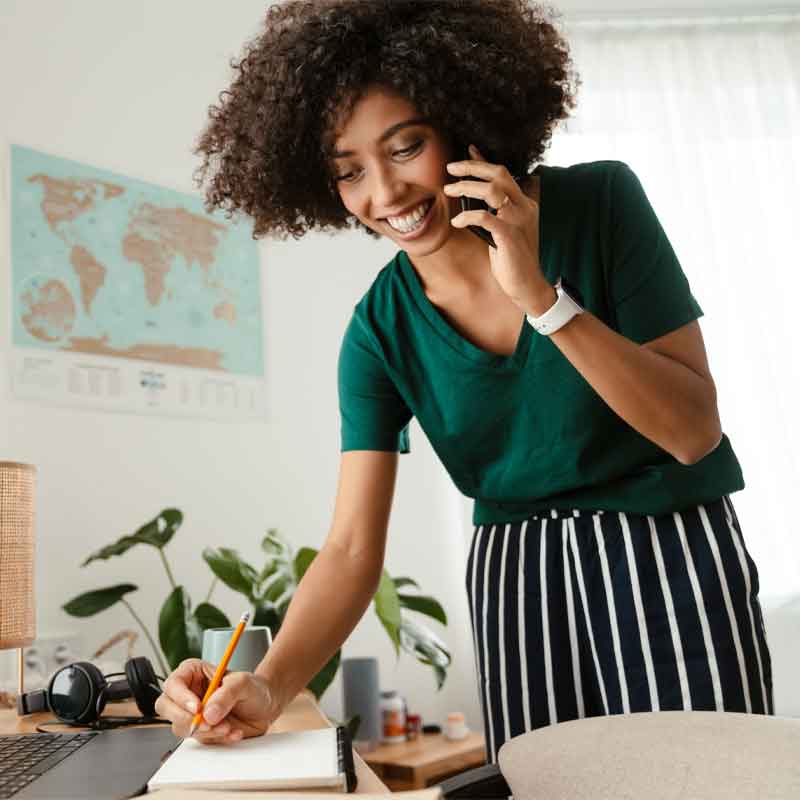 African American woman working on business tasks while on the phone